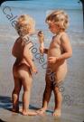 2 niños comiendo helado en playa.